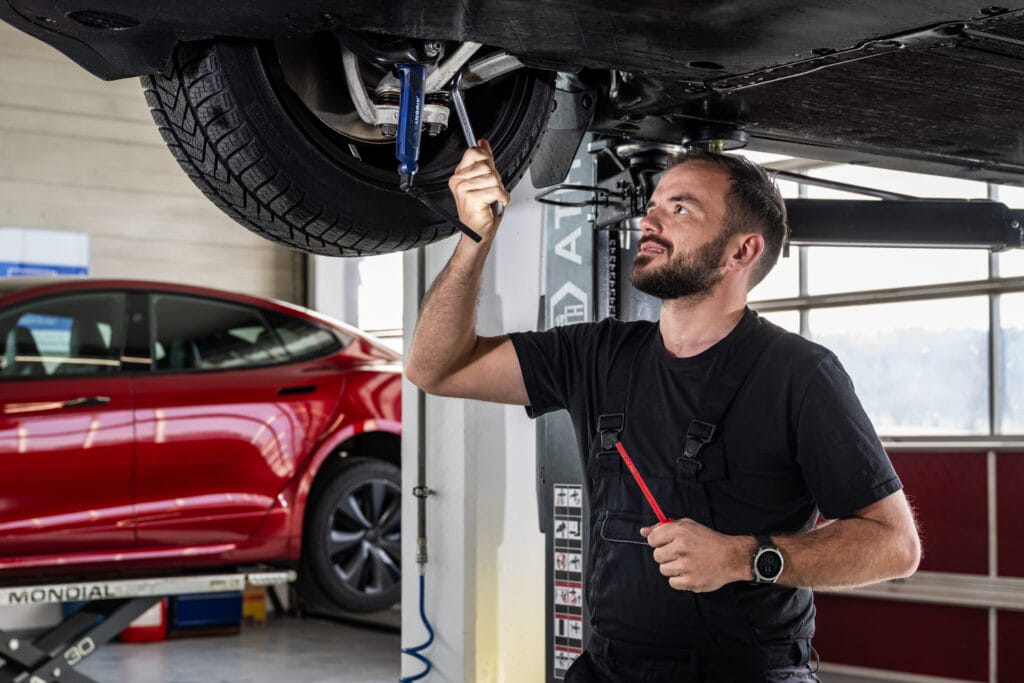 Mechaniker freie Tesla Garage an der Wartung des Autos